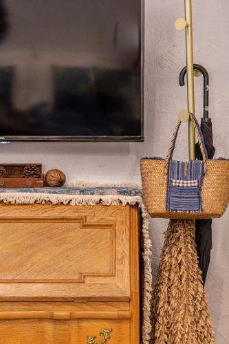 a television with a basket hanging on a wall at Silsopa Hostel in Nong Khai