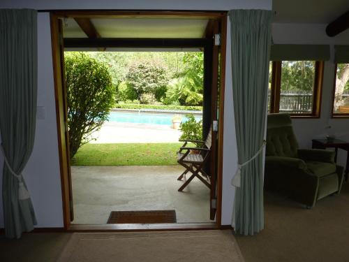 a door to a living room with a view of a pool at Thorold Country House in Thames