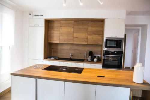 a kitchen with white cabinets and a wooden counter top at La Casa Machado 2 in Collioure