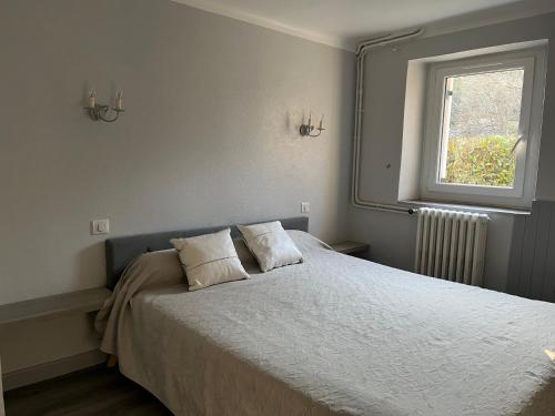a bedroom with a bed with two pillows and a window at Gite à Sarlat avec piscine in Sarlat-la-Canéda