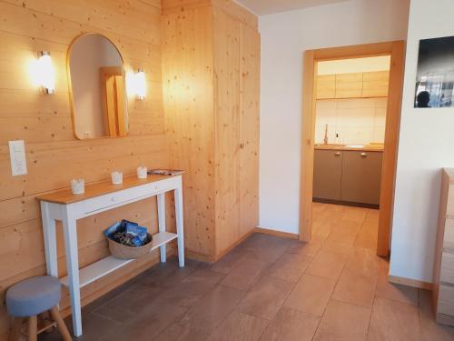 La salle de bains est pourvue d'une table, d'un miroir et d'un lavabo. dans l'établissement Le Fleuron - Cosy and well centered - 6 ppl, à Nendaz