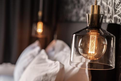 a close up of a glass bottle on a bed at Ethereal Athεns in Athens