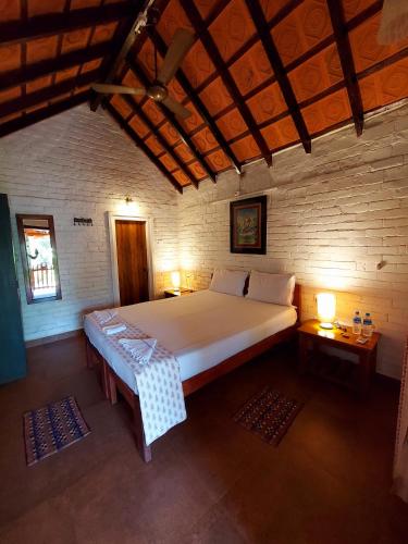 a bedroom with a large bed and two tables at OmBodhi Retreat in Kumta