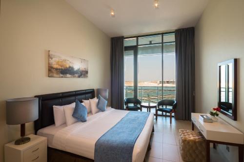 a hotel room with a bed and a balcony at Boudl Al Jubail in Al Jubail
