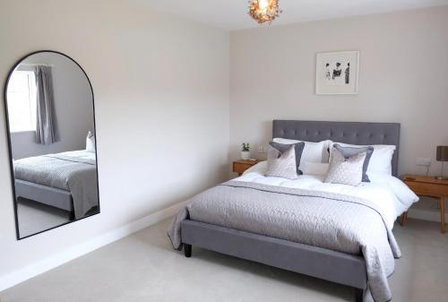 a bedroom with a bed and a mirror at Chaloners House, Free Parking, Large garden, Close to York Races & City Centre in York