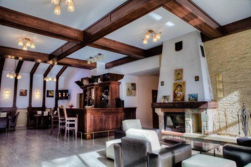 un grand salon avec une cheminée et des chaises dans l'établissement Vila Pinul si Mesteacanul, à Poiana Brasov