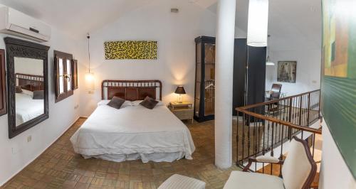 a bedroom with a large bed and a staircase at El Pensamiento Duplex in Ronda