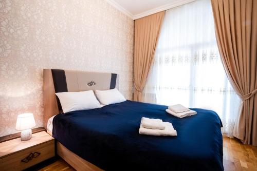 um quarto com uma cama azul com duas toalhas em Просторная квартира Баку em Baku