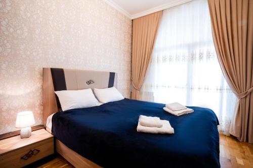 a bedroom with a blue bed with two towels on it at Просторная квартира Баку in Baku