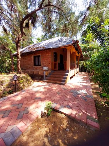 a house with a brick walkway in front of it at OmBodhi Retreat in Kumta
