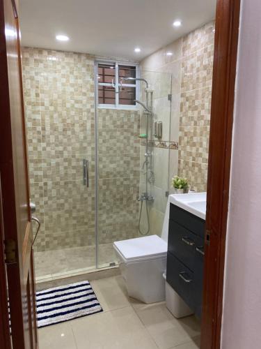 uma casa de banho com um chuveiro, um WC e um lavatório. em VIP Home em Santiago de los Caballeros