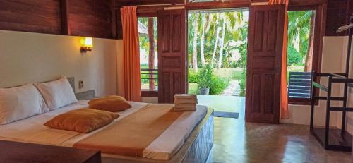 a bed in a room with a large window at Lagoon Paradise Beach Resort in Tangalle