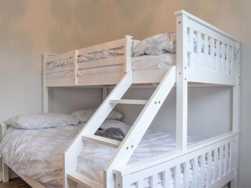 a white bunk bed in a childs bedroom at Barn Owls Holiday Bungalow in Salcombe Regis