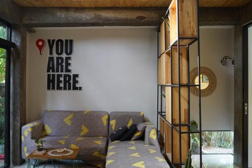 a living room with a couch and a book shelf at Happy House BnB Bromo backpacker in Probolinggo