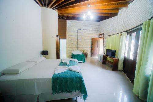 ein Schlafzimmer mit einem großen Bett und einem TV in der Unterkunft Pousada Toca dos Aventureiros in Barreirinhas