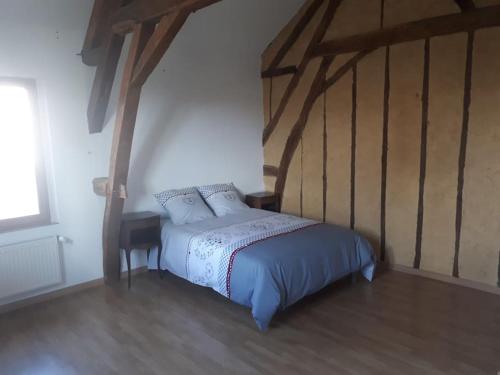 a bedroom with a bed with blue sheets and a window at Gîte¨ La Maison du sculpteur ¨ 