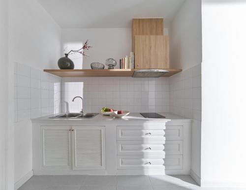 a kitchen with white cabinets and a sink at M Village Living Nguyễn Văn Hưởng in Ho Chi Minh City