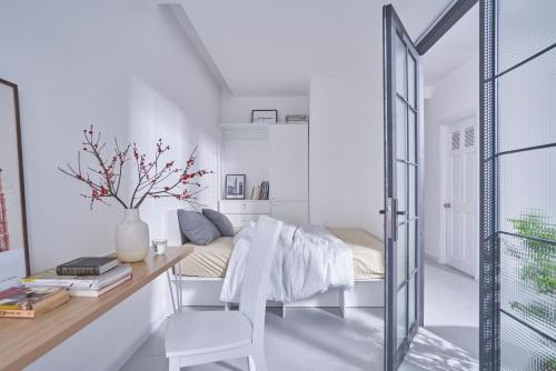 a bedroom with a desk and a bed in a room at M Village Living Nguyễn Văn Hưởng in Ho Chi Minh City