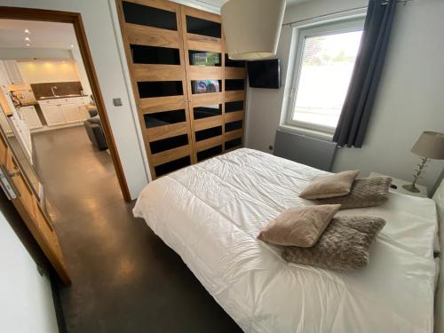 a bedroom with a bed with pillows and a window at Wimereux : calme, proche du centre et de la plage in Wimereux