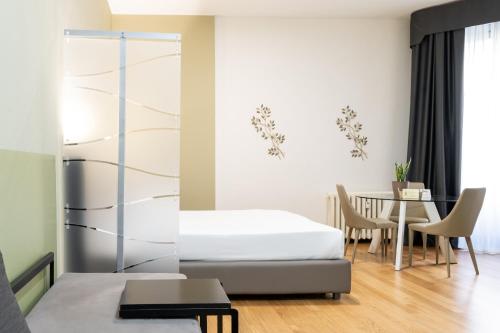 1 dormitorio con 1 cama y 1 mesa con sillas en Castello Guest House Milano, en Milán