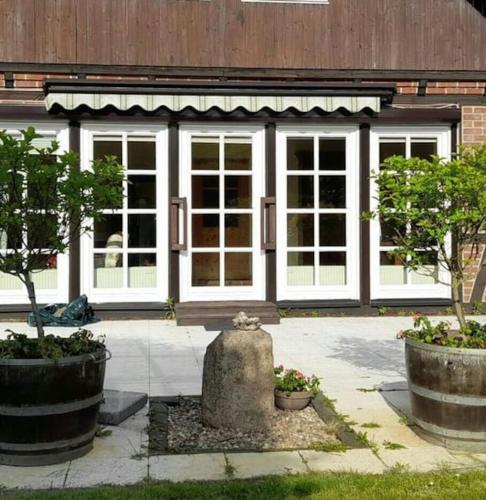 a building with white doors and trees in front of it at Ferienhaus Gartower See in Gartow