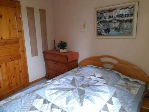 a bedroom with a bed and a wooden dresser at Ferienhaus Gartower See in Gartow