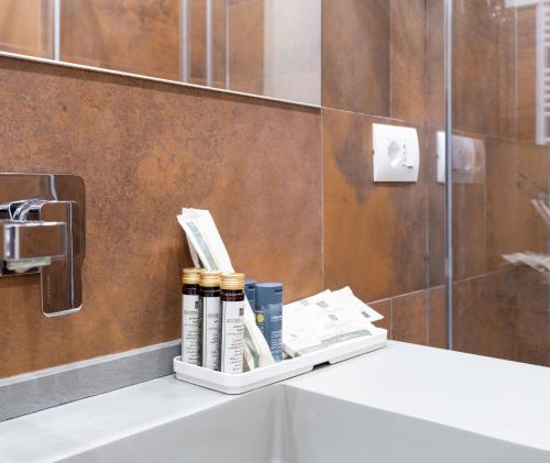 a bathroom with a shelf with books on a sink at Castello Guest House Milano in Milan