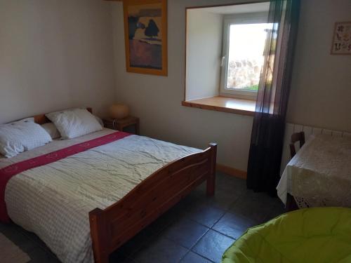 a bedroom with a bed and a window at La sérénité in Grazac