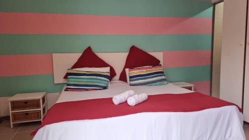 a bedroom with a bed with two towels on it at Epic Den Lodge in Phuthaditjhaba