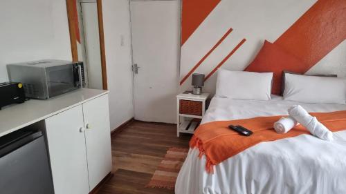 a small room with two beds and a tv at Epic Den Lodge in Phuthaditjhaba