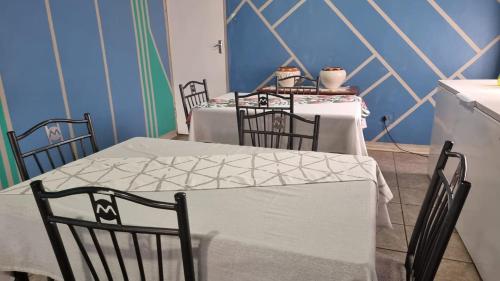 a dining room with three tables and four chairs at Epic Den Lodge in Phuthaditjhaba
