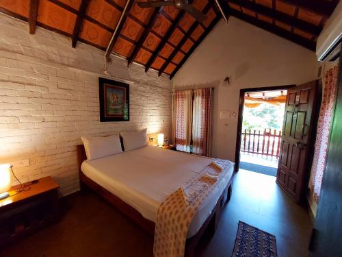 a bedroom with a bed in a room with a window at OmBodhi Retreat in Kumta