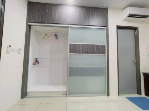 a closet with glass doors in a room at Double Storey Sweet Home 12pax @ Puncak Alam in Kuala Selangor