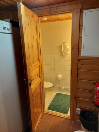 uma casa de banho com um WC e um chuveiro com uma porta em Vierumäki em Vierumäki