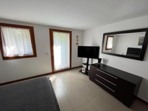 a living room with a large mirror and a television at La casa di Chicca in Noventa Padovana