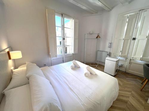 a bedroom with a large white bed with towels on it at The MO GOTIC in Barcelona