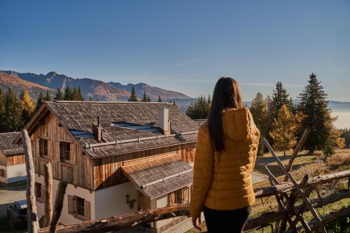 a woman standing on top of a house at Almdorf Omlach, Fanningberg in Weisspriach