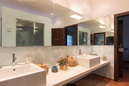 a bathroom with two sinks and a large mirror at Ca'stello23 in Sala Bolognese