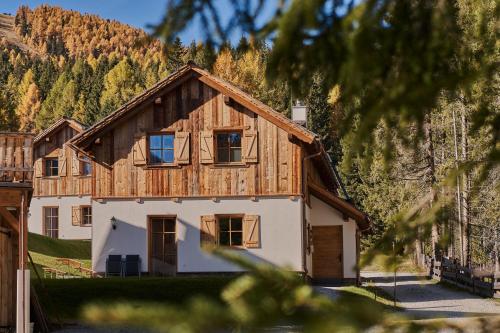 a house in the mountains with trees at Almdorf Omlach, Fanningberg in Weisspriach