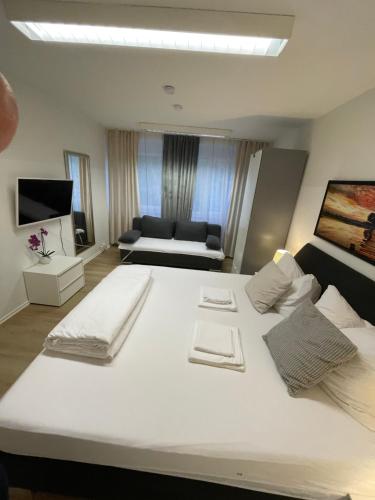 a large white bed in a room with a couch at Apartments Mainz in Mainz