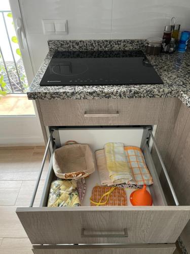 an open drawer in a kitchen with food at Apartamento nuevo con piscina en el centro "Doña Paca" in Ronda