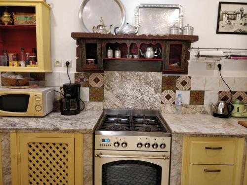 uma cozinha com um fogão e um micro-ondas em Dar Nadia em El Jadida