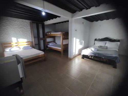 um quarto com 2 camas e 2 beliches em Hotel Estaciones em Guatapé