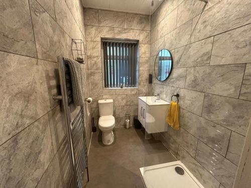 La salle de bains est pourvue de toilettes, d'un lavabo et d'un miroir. dans l'établissement The Bungalow, Thornton-Cleveleys, à Cleveleys