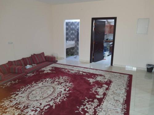 a living room with a couch and a red rug at Spacious Farm Stay with 3 bedroom & relaxing view in Remah