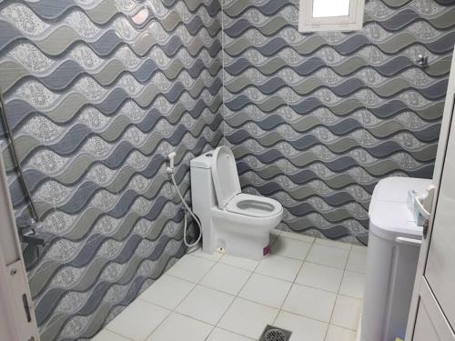 uma casa de banho com um WC e uma parede em Spacious Farm Stay with 3 bedroom & relaxing view em Remah