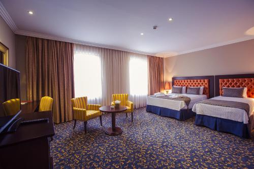 a hotel room with two beds and a television at Hotel Intourist Palace Batumi in Batumi