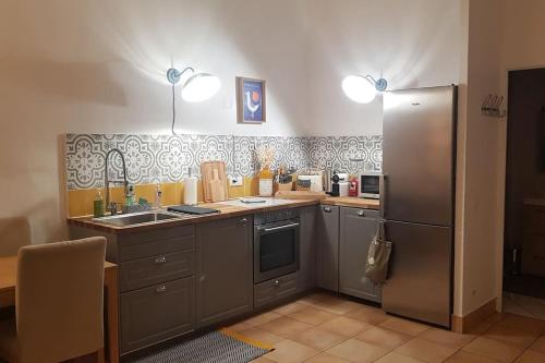 a kitchen with a sink and a refrigerator at Superbe 2 pièces avec grande terrasse, classé *** in Marseille