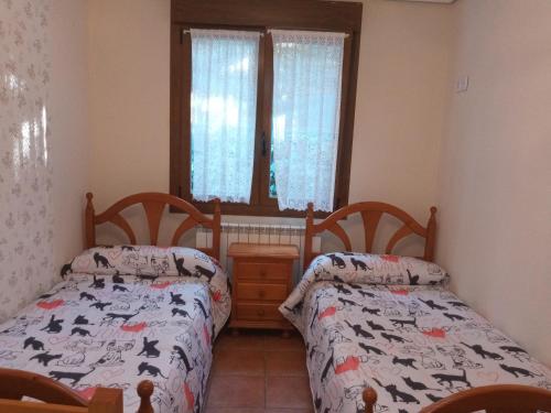 a bedroom with two beds and a window at Vivienda Turística San Martín in Sotés