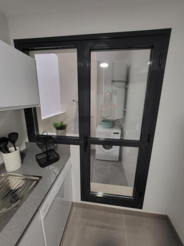 a kitchen with a sliding glass door to a refrigerator at Alazán Jerez II-Parking gratis-wifi in Jerez de la Frontera